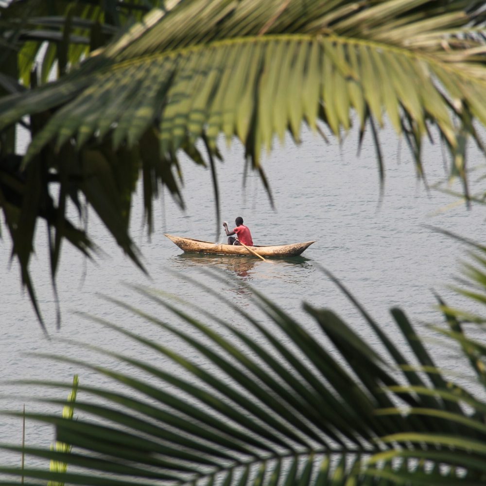 An African man in the old canoe fishing at the Lake Kivu, Rwanda
