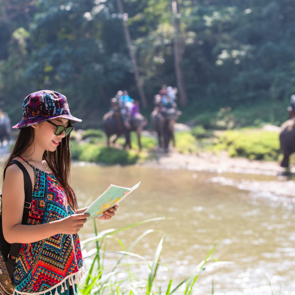 Female tourists on hand have a happy travel map.